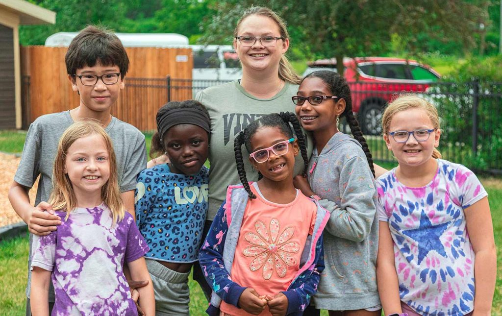 A group of students outside on the playground smiling at the camera