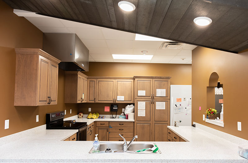 A kitchen with brown walls and white countertops