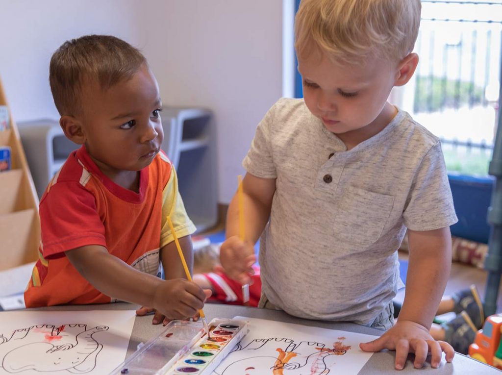 Two preschool students painting