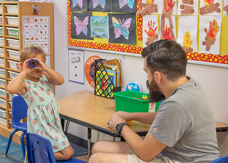 A preschooler and teacher working with blocks